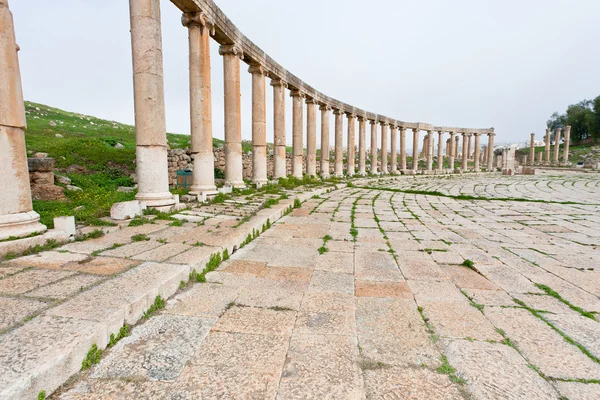 Colonnade en el foro oval romano en la ciudad antigua Jerash — Foto de Stock