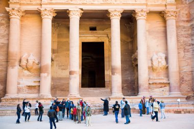 Tourists near gate of Treasury Monument in antique city Petra clipart