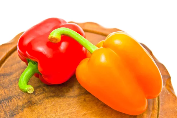 Twee paprika's op snijplank op wit — Stockfoto