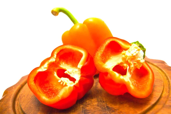 Paprika's op een snijplank op wit — Stockfoto