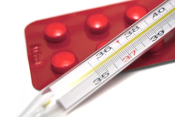 Thermometer and pills on white — Stock Photo, Image