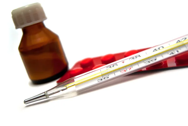 Frasco de medicamentos, comprimidos e termómetro — Fotografia de Stock