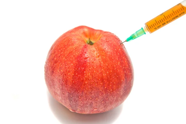 Roter Apfel und Spritze in Nahaufnahme auf weiß — Stockfoto