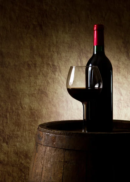Stilleven met rode wijn, fles, glas en oud vat — Stockfoto