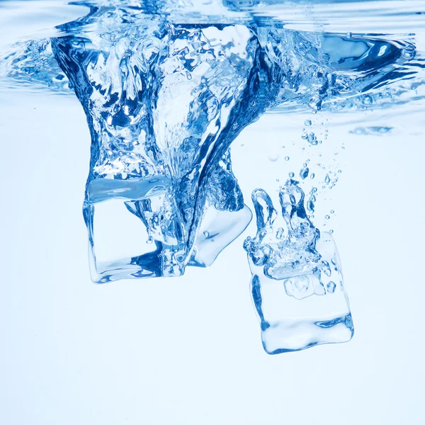 Ein Hintergrund von Blasen, die sich im blauen Wasser nach Eiswürfeln bilden. — Stockfoto