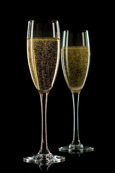 Ein Glas Champagner, isoliert auf schwarzem Hintergrund. Stockbild