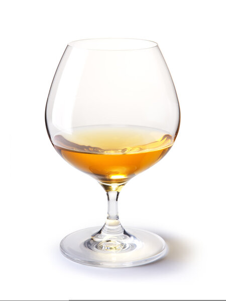 Коньячное стекло с золотым коньяком на белом
