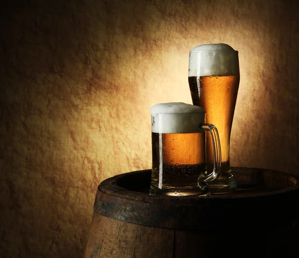 Stilleven van bier en vat op een oude steen — Stockfoto