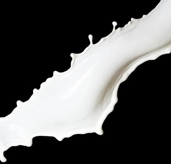 Брызги молока на черном фоне — стоковое фото