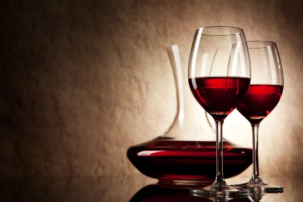赤ワインと古い石造りの背景にガラスのデカンター — ストック写真