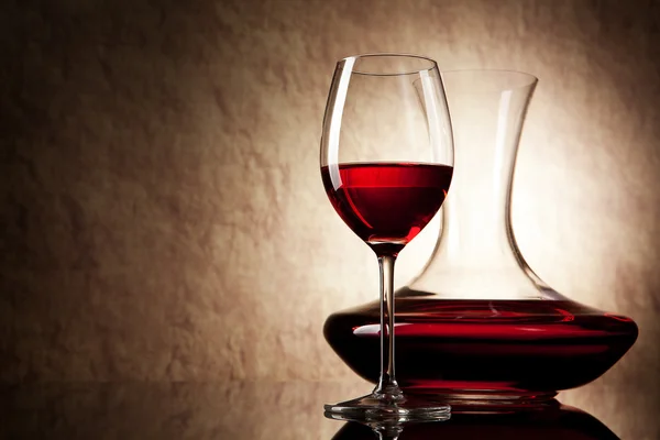Karaffe mit Rotwein und Glas auf altem Steinhintergrund — Stockfoto