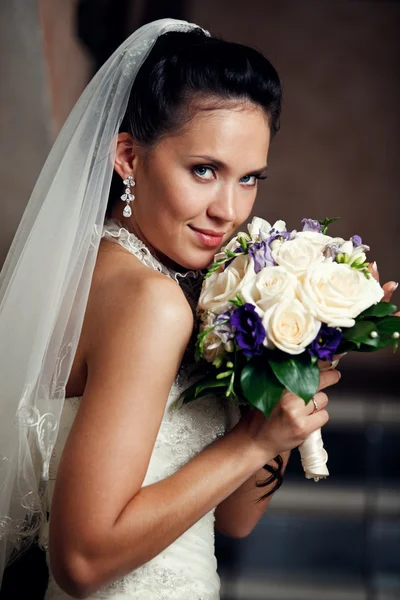 Mladá šťastná nevěsta s květinami — Stock fotografie