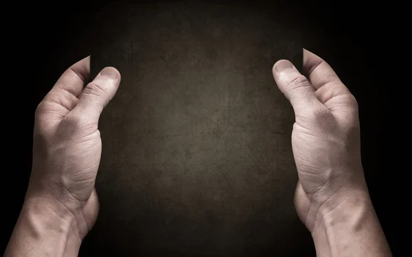 Handen breng donker papier op de donkere achtergrond — Stockfoto