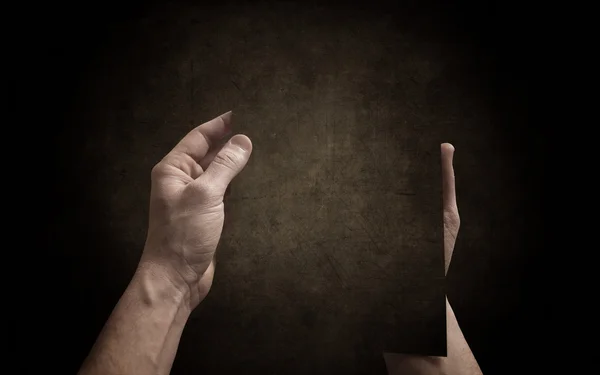 Handen breng het donker papier op de donkere achtergrond — Stockfoto