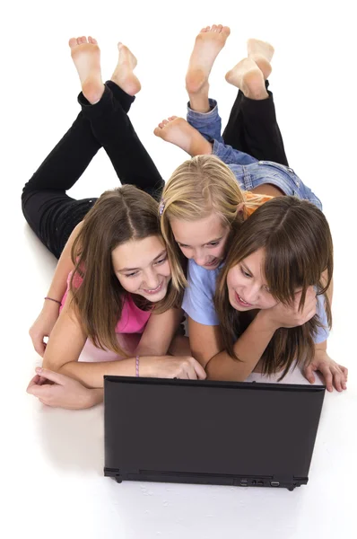 Три молодые девушки и ноутбук — стоковое фото