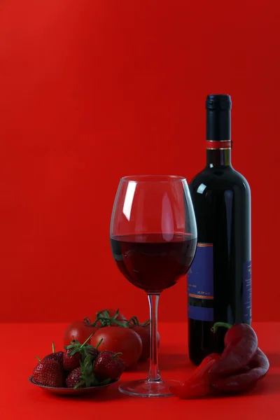 Red wine on red background with red fruit and vegetabe — Stock Photo, Image