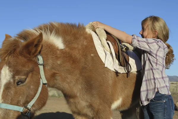 Mädchen sattelt ihr Pony — Stockfoto