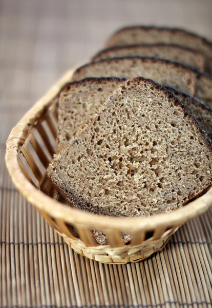 stock image The cut rye bread on a straw support