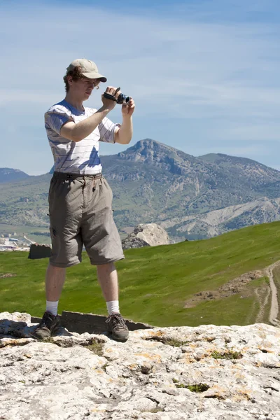 El turista quitando vídeo en las montañas — Foto de Stock