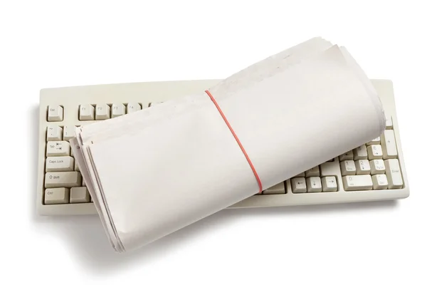 Computer toetsenbord en krant roll — Stockfoto