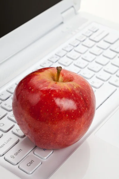 Computertastatur und roter Apfel — Stockfoto