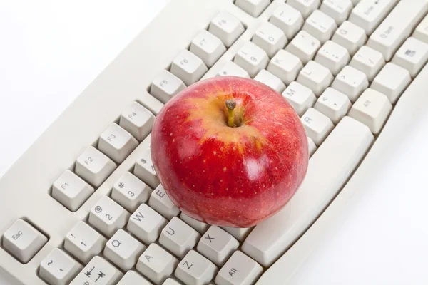 Teclado de ordenador y manzana roja — Foto de Stock