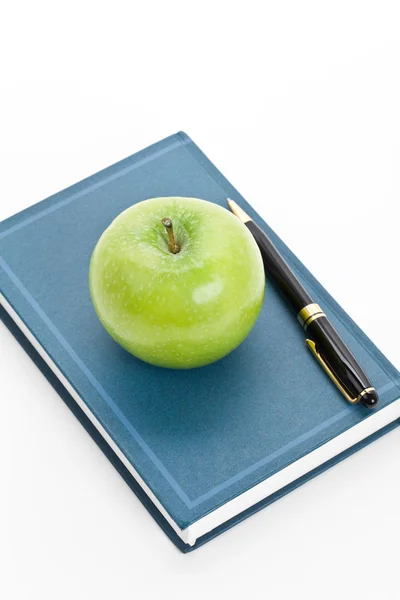 Grönt äpple och lärobok — Stockfoto