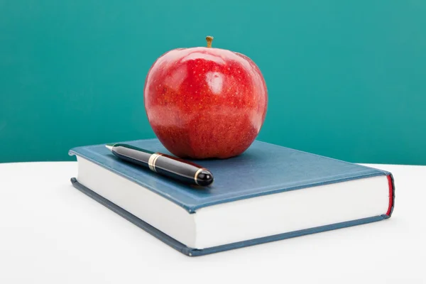 Červené jablko a učebnice — Stock fotografie