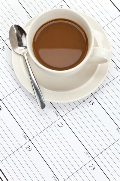 Кофейная чашка и календарь — стоковое фото