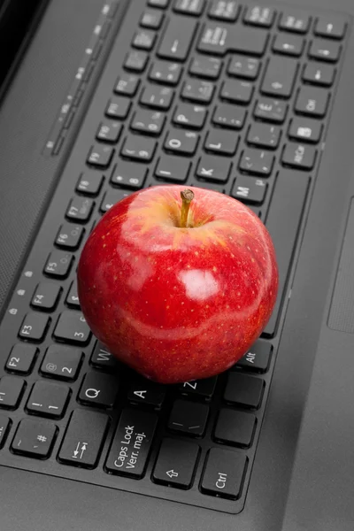 Počítačové klávesnice a červené jablko — Stock fotografie