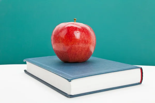 Rött äpple och lärobok — Stockfoto