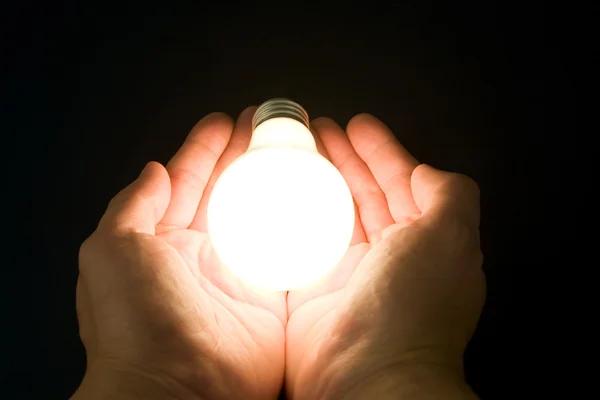 Hand och en ljus lampa — Stockfoto