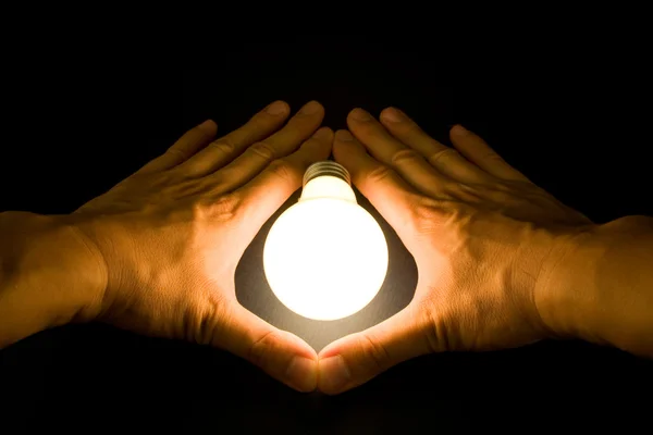 Mão e uma lâmpada brilhante — Fotografia de Stock