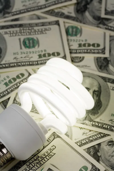 Компактная флуоресцентная лампочка и доллар — стоковое фото