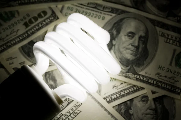 Lampadina fluorescente compatta e dollaro — Foto Stock