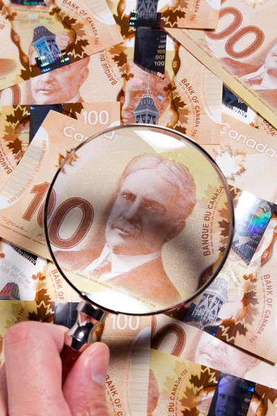 Lente d'ingrandimento e dollaro canadese — Foto Stock