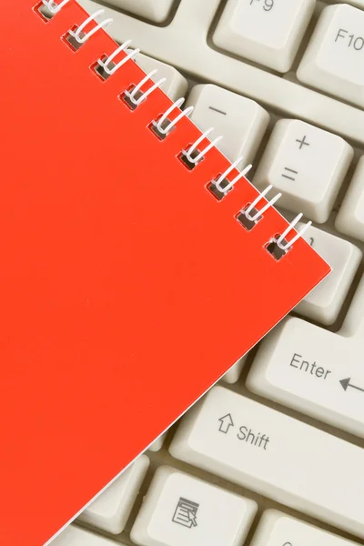 Червоний блокнот і клавіатура — стокове фото