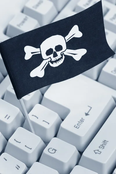 Bandera pirata y teclado de ordenador —  Fotos de Stock
