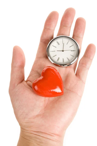 Часы и красное сердце — стоковое фото