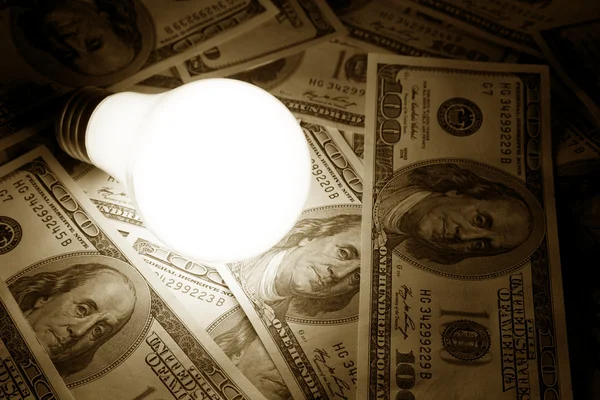 Lâmpada de luz brilhante e dólar — Fotografia de Stock