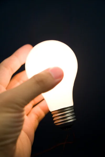 Hand holding a Bright Light Bulb Stock Image