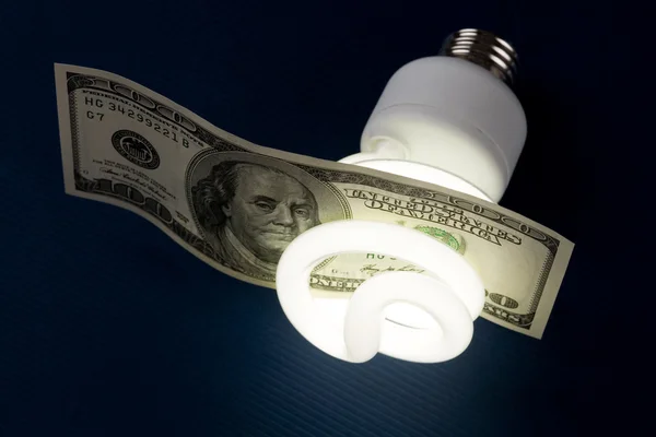 Kompakt fluorescerande glödlampa och dollar — Stockfoto