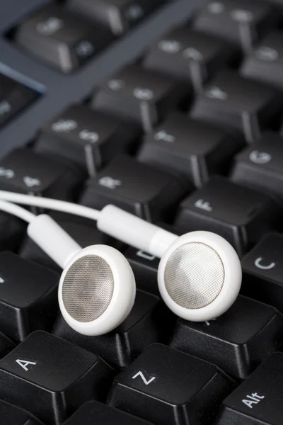 Headphones and black keyboard — Stock Photo, Image