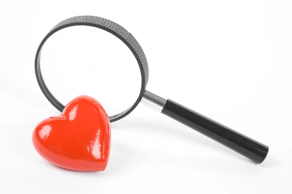 Rött hjärta och förstoringsglas — Stockfoto