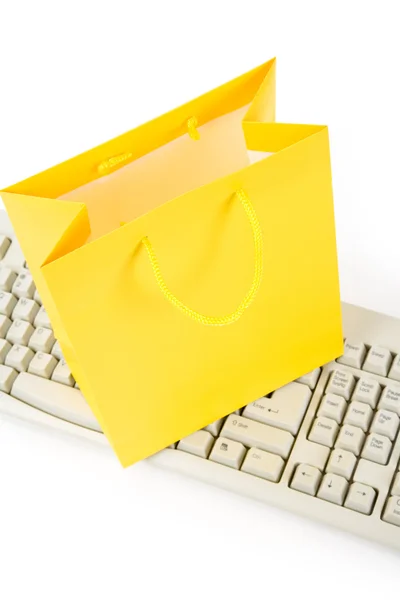 Bolsa de compras amarilla y teclado del ordenador —  Fotos de Stock