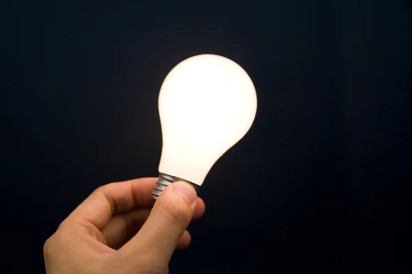 Hand som håller ett ljus lampa — Stockfoto