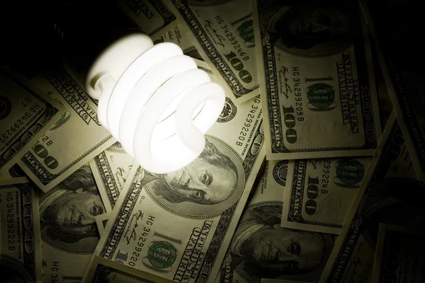Compact Fluorescent Light bulb and dollar — Stock Photo, Image