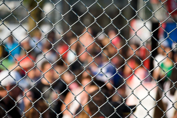 Metal netting and crowd — Stock Photo, Image