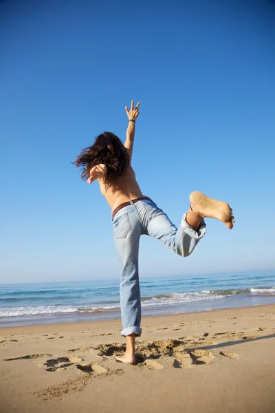 Женщина достигает неба на пляже — стоковое фото
