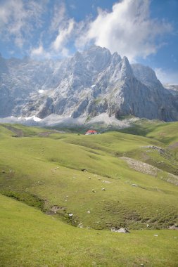 Clouds cliff and cottage in Cantabrian mountains clipart